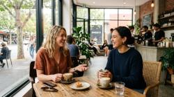 Two friends having a relaxed conversation about starting a friends with benefits arrangement in an Australian cafe